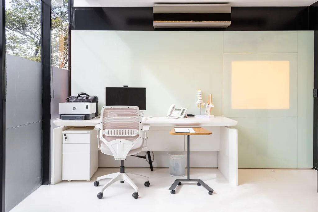 Sala da clínica com mobiliário elegante e iluminação suave, projetada para acolher pacientes