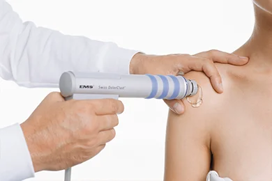 Paciente recebendo tratamento por ondas de choque para dor musculoesquelética