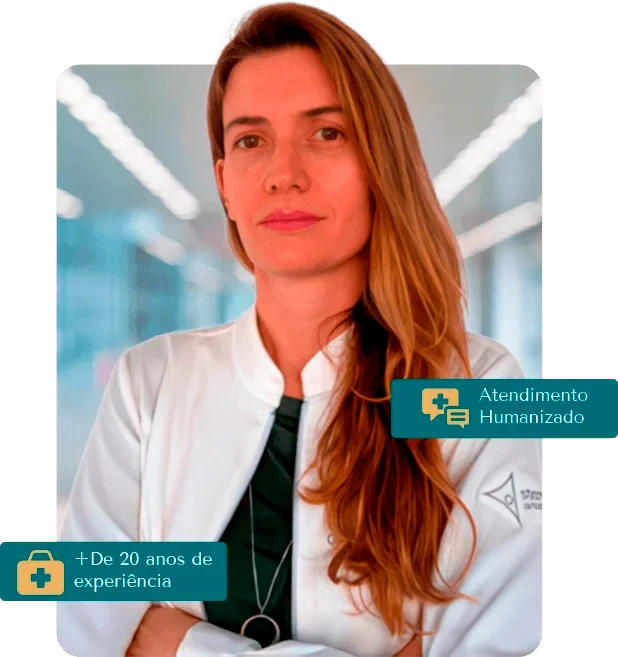 Foto da Dra. Karen Voltan sorrindo, usando jaleco branco, no consultório especializado em ortopedia oncológica